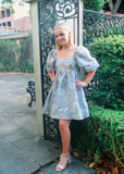 Calling all girly girls and Bridgerton fans, this is the perfect dress for you! Large white floral print over a gorgeous periwinkle color that has a lot been of sheen to make sure you shine bright like the seasons first diamond. This baby doll dress has a square neckline in the front and back and oversized puffy elastic sleeves.